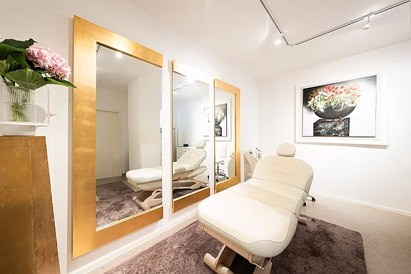 große Kosmetikkabine mit Spiegeln, Behandlungsstuhl und Dekoration